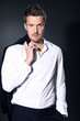 Foto: Junger sportlicher Mann in Fashion Pose Jacke über Schulter Junger sportlicher Mann in Fashion Pose Jacke über Schulter
