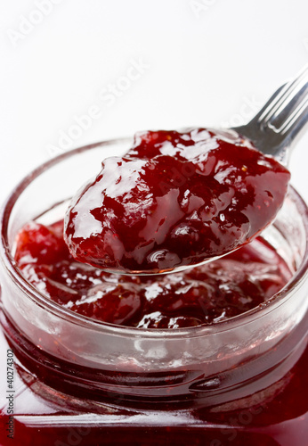 Foto: Close up of thick sweet strawberry jam preserve on a spoon. Close up of thick sweet strawberry jam preserve on a spoon.