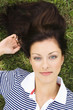 Young woman lying on grass, portrait