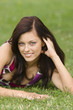 Young woman lying on grass, portrait