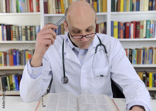 Photo: Doctor looking up information on medicine Doctor looking up information on medicine