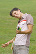 Young man holding badminton racquet in park
