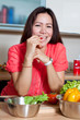 Happy woman in the kitchen making a salad