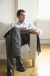 Mid adult man holding magazine, looking away