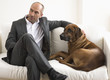 Businessman sitting on sofa with dog