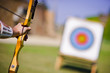 Archer who holds his bow aims at target