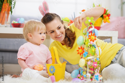Photo: Mother and baby making Easter decoration Mother and baby making Easter decoration