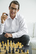 Mid adult holding chess piece, portrait
