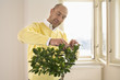 Mature man pruning plant with scissors