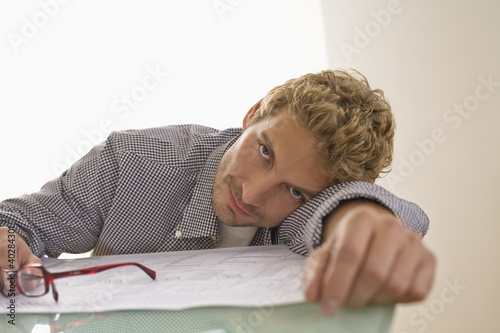Photo: Mid adult man leaning on table, portrait Mid adult man leaning on table, portrait