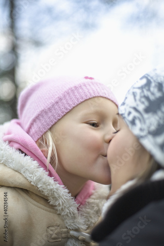 Photo: Daughter kissing mother, side view, close-up Daughter kissing mother, side view, close-up