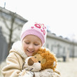 Girl holding stuffed lion, smiling