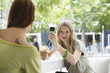Young woman photographing with mobile phone, smiling