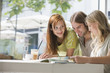 Photo: Friends looking at map, smiling Friends looking at map, smiling