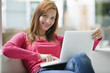 Young woman using laptop, smiling, portrait