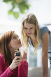 Photo: Young women looking at mobile phone Young women looking at mobile phone