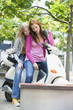 Young women sitting on motor scooter, smiling