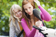 Young women looking at side-view mirror, smiling