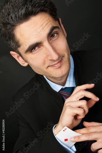Photo: Young crooked gambler with cards. Young crooked gambler with cards.