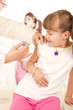 Doctor doing vaccine injection to blond little girl Doctor doing vaccine injection to blond little girl