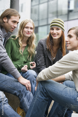 Photo: Young couples sitting together, smiling Young couples sitting together, smiling