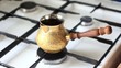 Brew coffee in brassy cezve on gas-stove