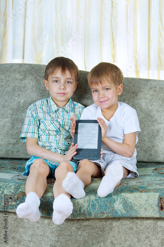 Photo: Two reading boys. With electronic book Two reading boys. With electronic book