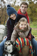 Girl sitting with parents and dog, smiling