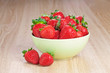 Foto: strawberries in a plate on the wooden table strawberries in a plate on the wooden table