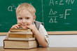 Cheerful smiling   child resting on a stack of books