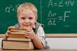 Cheerful smiling  little boy sitting at the table.