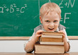 Cheerful smiling   child resting on a stack of books