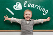 Cheerful smiling child at the blackboard.