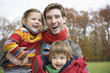 Father holding son and daughter, smiling, portrait
