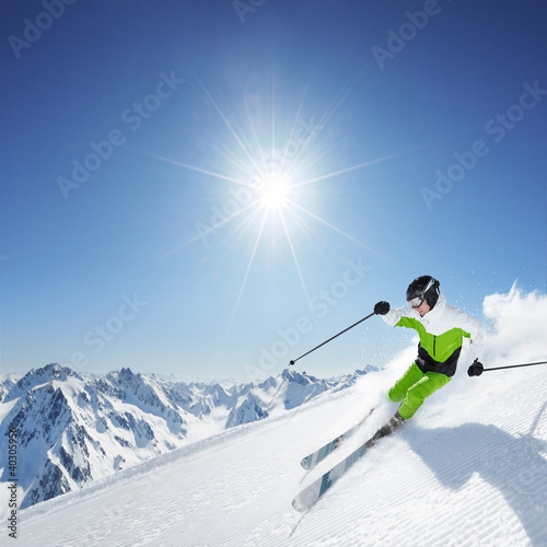 Foto: Skier in mountains, prepared piste and sunny day Skier in mountains, prepared piste and sunny day