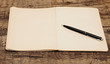 old notebook with pen on a wooden table