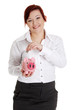 Woman putting euro coin in piggy bank.