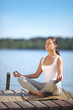 beautiful young girl training yoga near a lake beautiful young girl training yoga near a lake