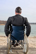 Mann sitzt im Rollstuhl in der Natur
