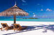 Foto: Chairs and umbrella on a beach with shadow from palm tree Chairs and umbrella on a beach with shadow from palm tree
