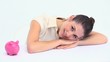 Young woman resting on a table with a piggy bank