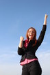 Pretty redhead woman is celebrating with hands up