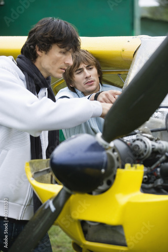 Photo: Young man repairing airplane Young man repairing airplane