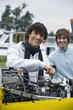 Young man screwing in airplane engine, smiling, portrait