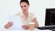 Female worker reading a file while sitting at a desk