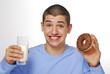 Niño sujetando un dulce de chocolate y un vaso de leche.