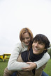 Young man giving piggyback to young woman, portrait