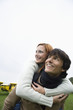 Young man giving piggyback to young woman
