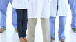Happy medical team placing their hands in their pockets