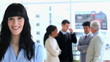Brunette businesswoman standing in front of her team